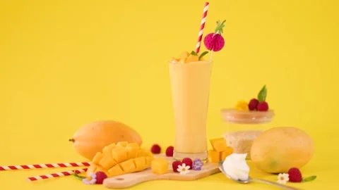 Refreshing Mango Smoothie with Tropical Fruit on Yellow Background Stock Footage 324945426