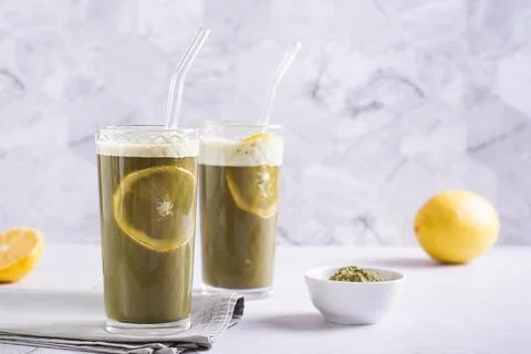 Refreshing matcha tea with lemon in glasses with straws on the table Stock Photos