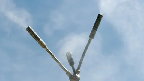 Refreshing Metal Nozzles Release Cool Mist Against a Clear Blue Sky Stock Footage 333768084