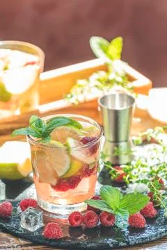 Refreshing mint cocktail mojito with rum, lime, mint, thyme, ice and raspberr Stock Photos