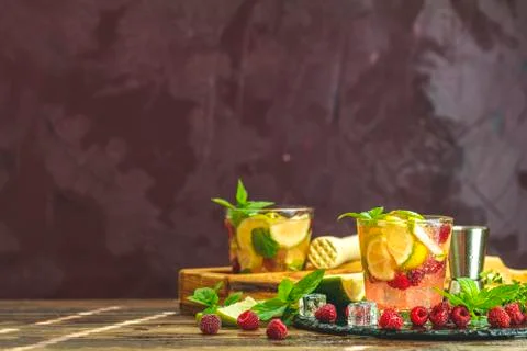 Refreshing mint cocktail mojito with rum, lime, mint, thyme, ice and raspberr Stock Photos