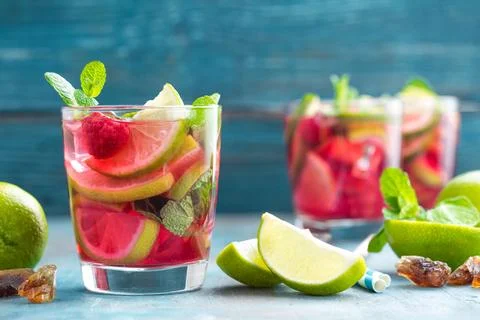 Refreshing mint cocktail mojito with rum, lime and raspberry, cold drink or.. Stock Photos