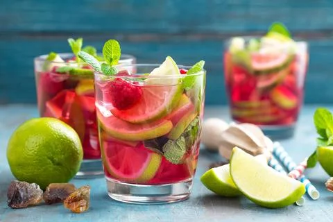 Refreshing mint cocktail mojito with rum, lime and raspberry, cold drink or.. Stock Photos