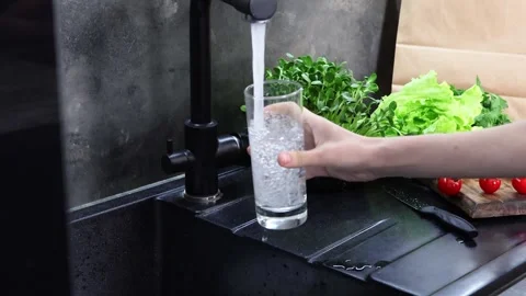 Refreshing moments in the kitchen with water and fresh greens Stock-Footage 296319421