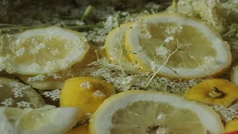 Refreshing natural drink. Lemon slices and elder flowers in water Stock Footage 130455873