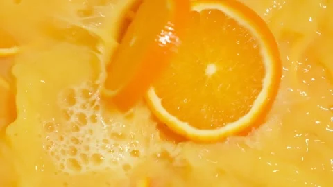Refreshing orange juice explosion with falling fruit slices Stock Footage 328362381