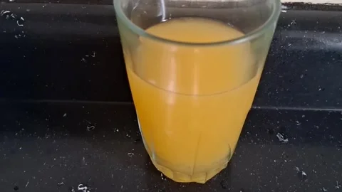 Refreshing orange juice inside a clear glass motion video footage Stock Footage 339374512