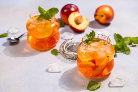 Refreshing peach iced tea with mint leaf garnish Stock Photos