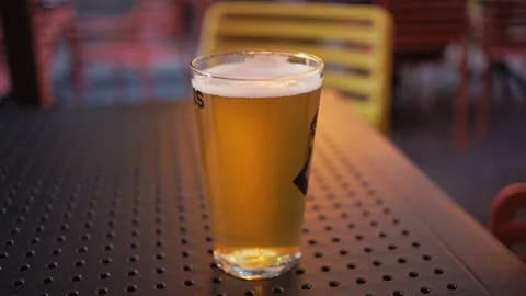 A Refreshing Pint of Cold Beer, Perfectly Positioned on a Table in a Calm and Stock Footage 314826989