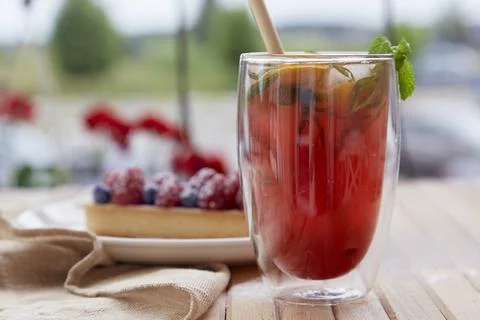 Refreshing raspberry-mint orange lemonade with cane straw outside. Raspberry Stock Photos