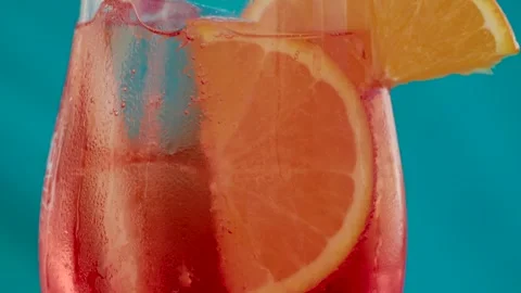 A refreshing red cocktail with orange slices and ice cubes in a transparent.. Stock Footage 339375679