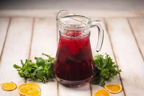 Refreshing red fruit drink with orange slices Stock Photos