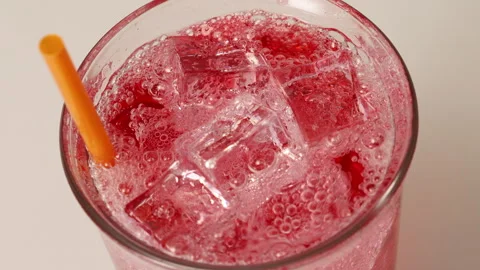 Refreshing Red Soda with Bubbles and Ice Cubes Glass Featuring Orange Straw.. Stock Footage 314331574