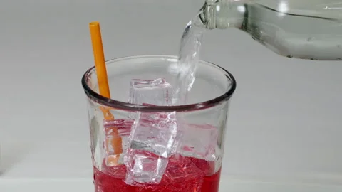 Refreshing Red Soda with Ice Cubes and Orange Straw Creating Bubbles in Cle.. Stock Footage 314331614