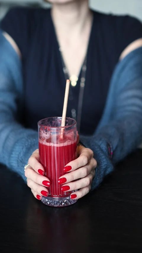 Refreshing Red strawberry Smoothie Delight in Chic Glass Held by Woman with Stock Footage 304275130