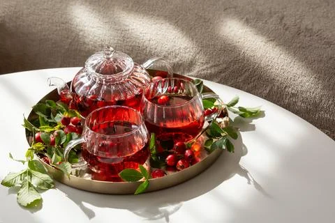 Refreshing Rosehip Tea Served in Elegant Glassware on a Round Tray Foto stock