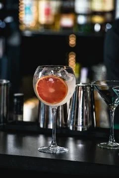 Refreshing ruby red coctail with grape fruit isolated on a bar background Stock Photos