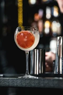 Refreshing ruby red coctail with grape fruit isolated on a bar background Stock Photos
