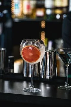 Refreshing ruby red coctail with grape fruit isolated on a bar background Foto stock
