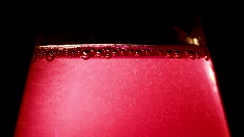 Refreshing ruby red drink with condensation and bubbles in a bottle on a dark Stock Footage 320419475