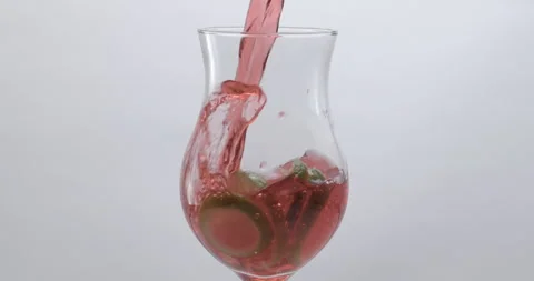 Refreshing Slow Motion Pour: Liquid Filling a Glass with Fruit and Ice - Vibrant Stock Footage 273532227