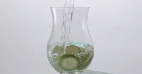Refreshing Slow Motion Pour: Liquid Filling a Glass with Fruit and Ice - Vibrant Stock Footage 273532241