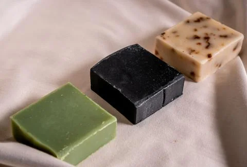 Refreshing soaps made of handmade aloe vera, charcoal and roses on a white ta Stock Photos