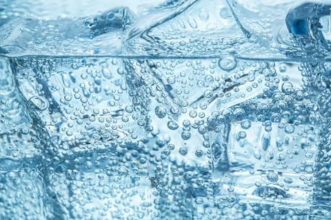 Refreshing soda water with ice cubes as background, closeup Stock Photos