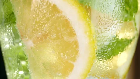 Refreshing soft drink with ice. lemon and mint in a glass Vidéo 156902102