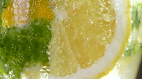 Refreshing soft drink with ice. lemon and mint in a glass Vidéo 156936362