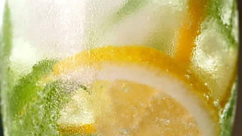 Refreshing soft drink with ice. Mojito with lemon and mint in a glass Vidéo 156340649