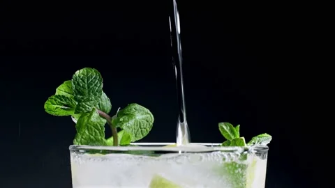 A refreshing soft drink. Mojito is poured into a glass close-up. Lemon mint Vídeo Stock 148162153