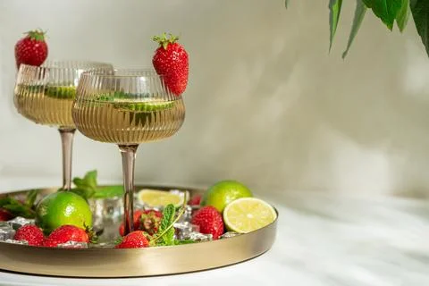 Refreshing strawberry lime cocktails on tray with ice and mint Stock Photos