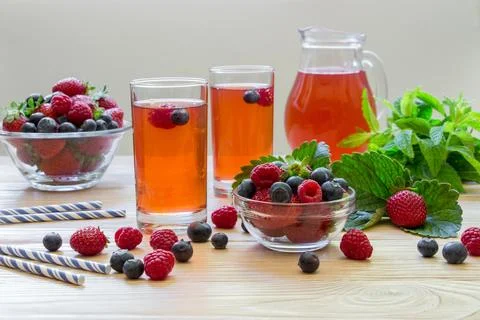 Refreshing summer beverage setup with raspberries, blueberries, mint leaves, and Stock Photos