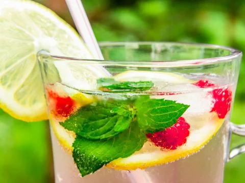 Refreshing summer cocktail with lemon, raspberry and mint close-up Stock Photos