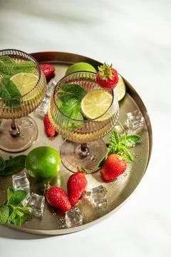Refreshing summer cocktails with mint, lime, and fresh strawberries on a tray Stock-Fotos