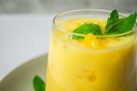 Refreshing summer drink decorated with peppermint leaves - mango lassi drink Foto stock