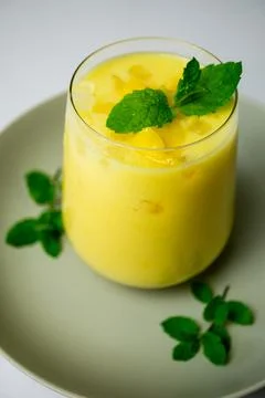 Refreshing summer drink decorated with peppermint leaves - mango lassi drink Foto stock