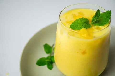 Refreshing summer drink decorated with peppermint leaves - mango lassi drink Foto stock