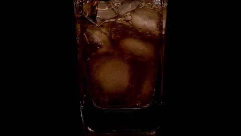 Refreshing summer drink. Ice and cola. Close up on cola filling a glass with ice Video stock 150055734