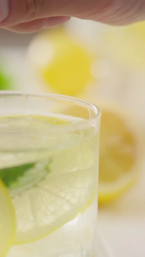 Refreshing summer drink preparation with mint and lemon in a bright kitchen Stock Footage 331724175