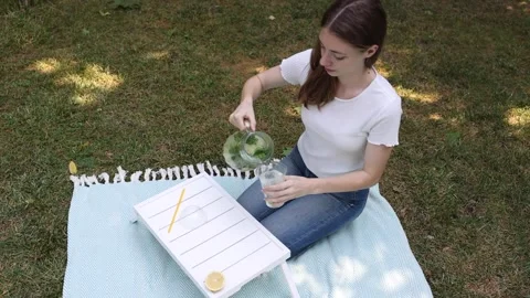 Refreshing summer drink preparation in a serene outdoor setting Stock Footage 297360932