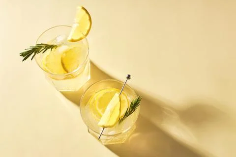 Refreshing summer drinks with fresh lemon garnished with a sprig of rosemary on Stock Photos
