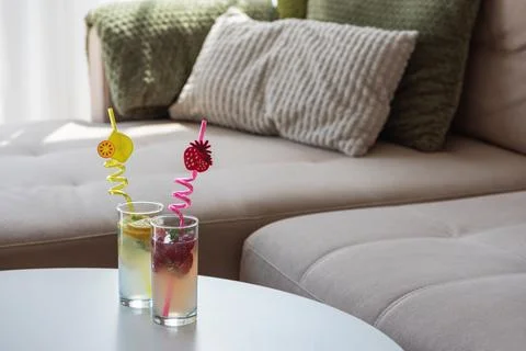 Refreshing summer drinks with fruit on modern couch Stock Photos