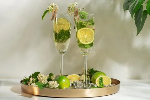 Refreshing summer drinks with lime, mint, and flowers Stock Photos