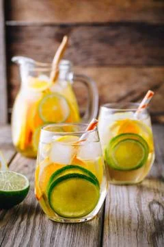 A refreshing summer ice-cold drink. White wine sangria in glass with lime, le Stock Photos