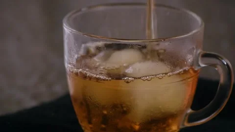Refreshing sweet tea pouring into a clear glass cup with ice Video stock 335835780