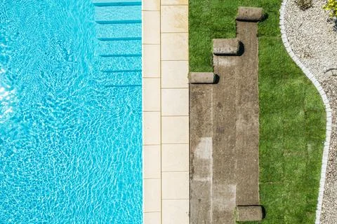 Refreshing Swimming Pool Area With Lounge Spots Beside Grassy Landscape 스톡 사진