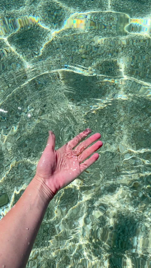 Refreshing Touch: A Hand Submerged in Crystal Clear, Shimmering Water, Capturing Video stock 318913984