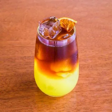 Refreshing two tone beverage with ice and a citrus garnish on a wooden table Stock Photos